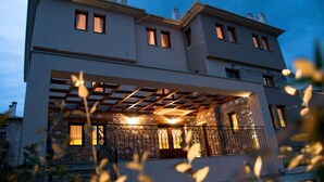 A modern two-story house with a covered patio and stone facade. - Belina Hotel (Volos)