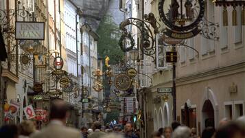 Una calle concurrida con letreros ornamentales y una multitud de gente.