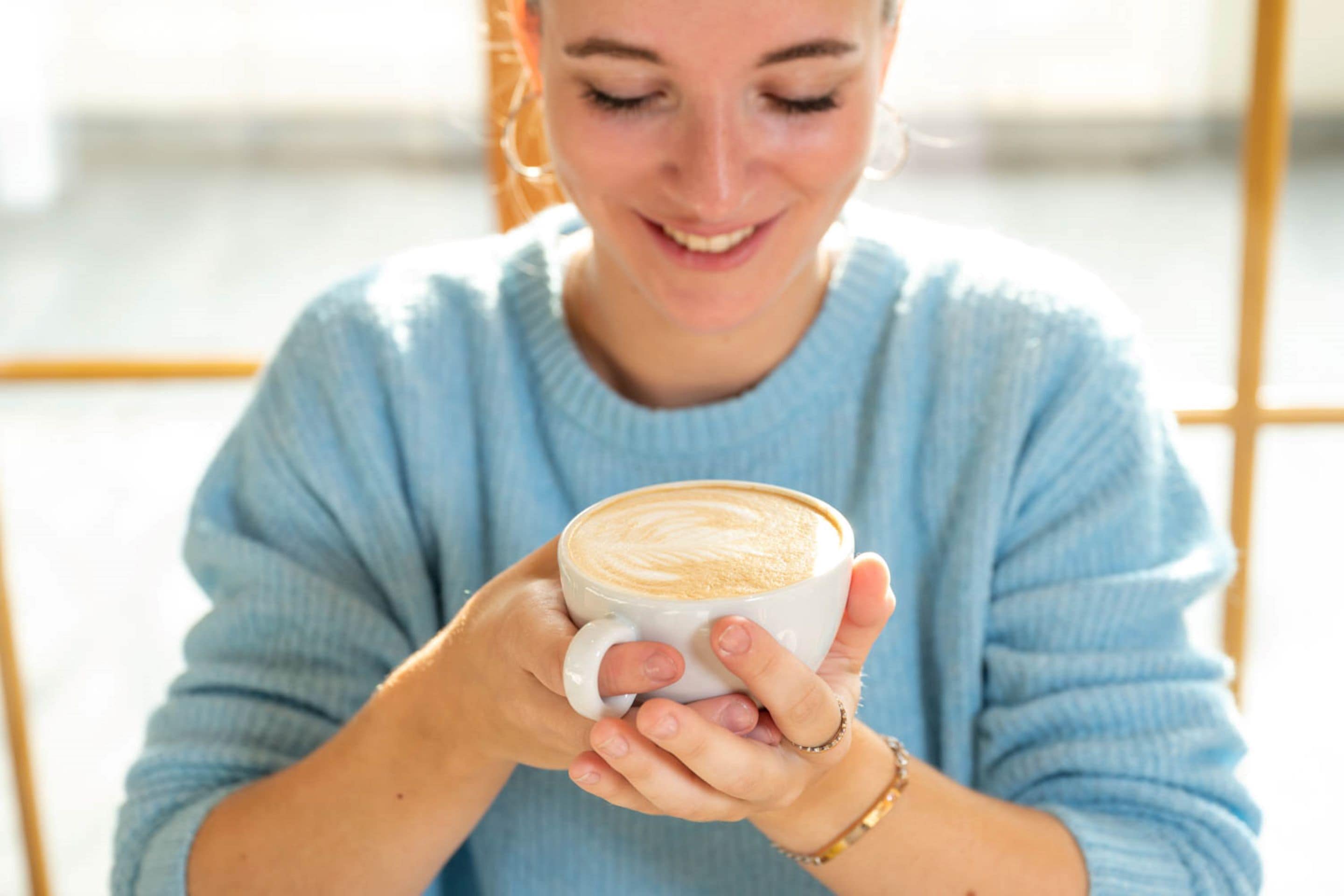 A person holding a cup of coffee.
