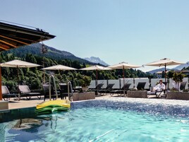Una piscina al aire libre, una piscina en la azotea, tumbonas