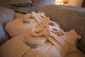A bed with neatly folded towels and a round, clear object on the bed. - Hotel Solstein (Seefeld in Tirol)