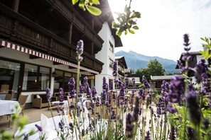 A restaurant with outdoor seating, surrounded by mountains and lavender plants. - Hotel Solstein (Seefeld in Tirol)