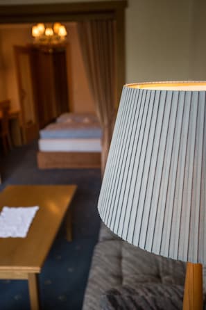 A hotel room with a bed, a bedside table, a lamp, and a curtain. - Hotel Solstein (Seefeld in Tirol)