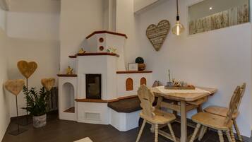 Enjoy meals in this charming dining area with a wooden table and four matching chairs, a heart-shaped mirror, and a wall-mounted light fixture.