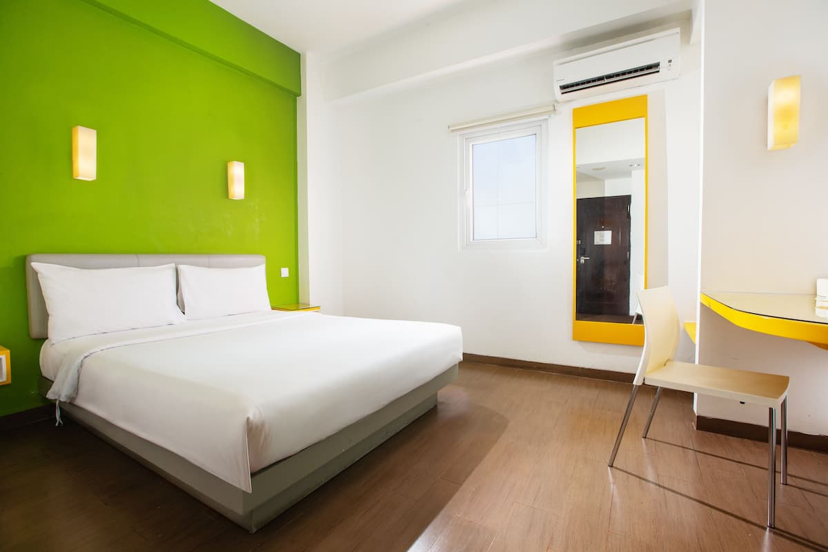 Ein Hotelzimmer mit Bett, Schreibtisch und Stuhl.