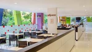 Un restaurant moderne doté d’un long comptoir, de nombreuses tables et de chaises.