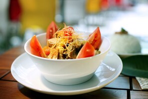 A bowl of food with vegetables and noodles on a white plate. - favehotel Kuta Square (Kuta)