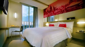 A hotel room with a large bed, a desk with a chair, a TV, and a balcony with a view. - favehotel Kuta Square (Kuta)