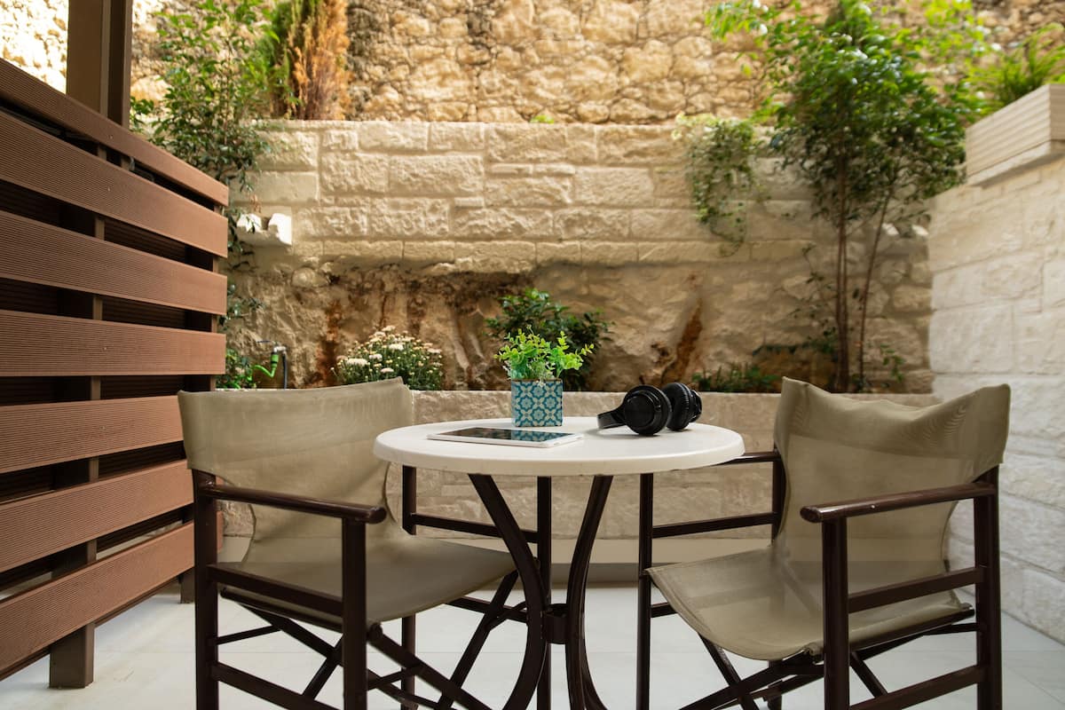 A round table with two chairs, a tablet, a blue vase, and headphones on it.