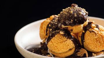 Un piattino con éclair e salsa al cioccolato.