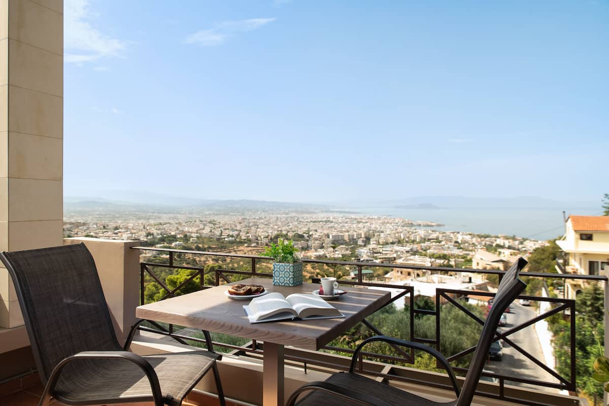 A balcony with a table, chairs, and a book.
