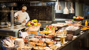 A buffet with various food items and a chef preparing food. - La Cordée des Alpes (Bagnes)