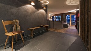A modern interior with a wooden bench, a fur-covered chair, and a dining table. - La Cordée des Alpes (Bagnes)