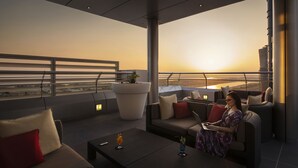 A modern rooftop lounge with a sofa, a coffee table, and a laptop. - Centro Capital Centre (Abu Dhabi)