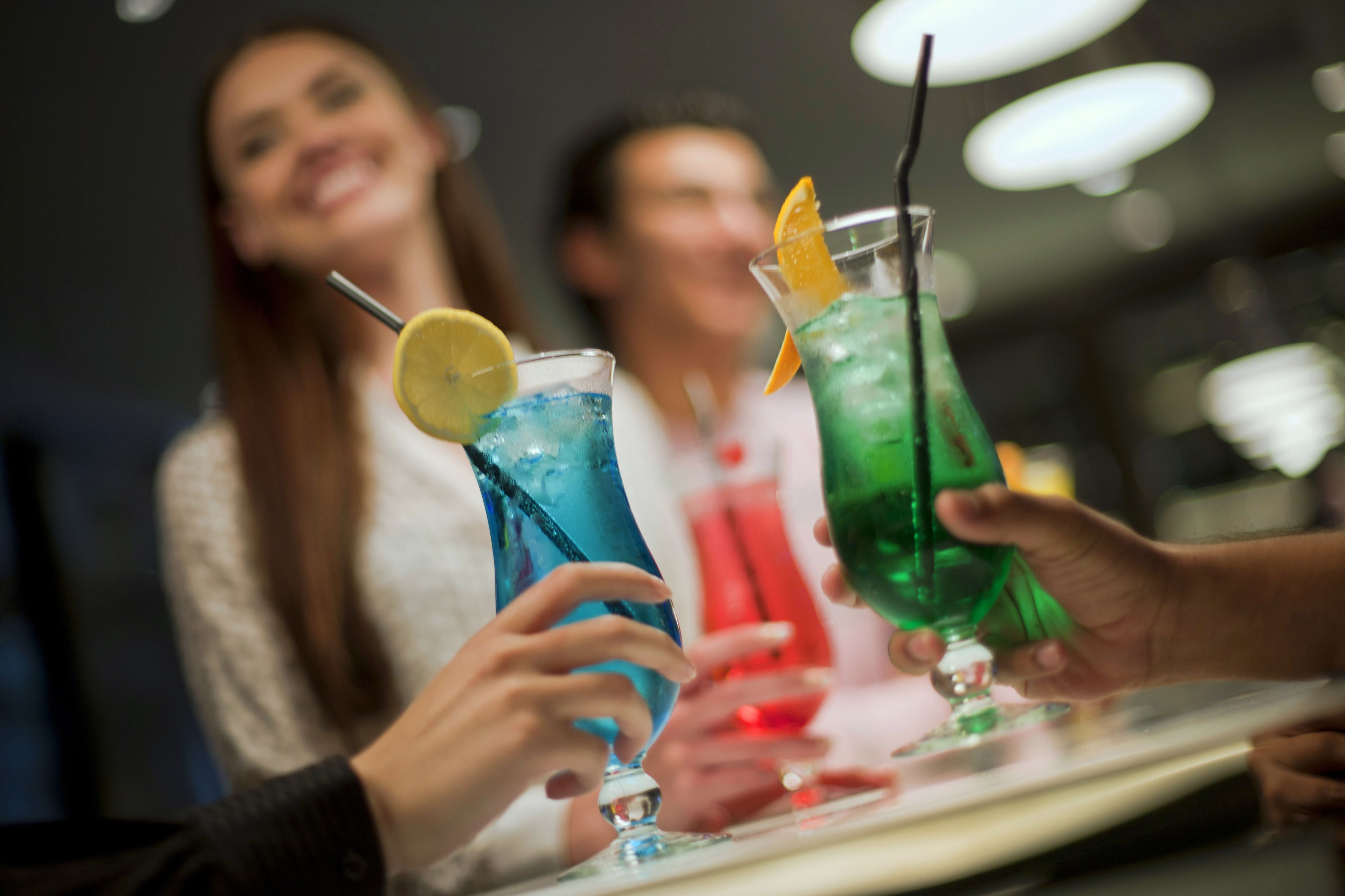 Un bar con gente sosteniendo bebidas.