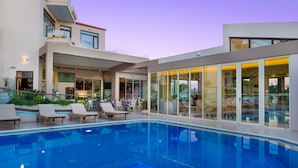 A modern house with a swimming pool, outdoor seating, and large windows. - Oscar Suites & Village (Chania)