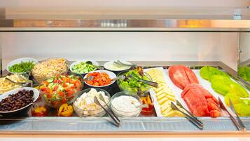 A buffet with various food items including salads, cheeses, and fruits.