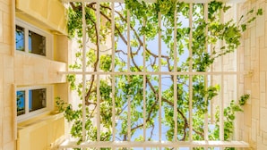 A building with a white balcony structure and green vines growing on it. - Anna Maria Village (Hersonissos)