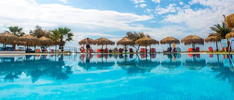 Piscine extérieure, parasols de plage, chaises longues