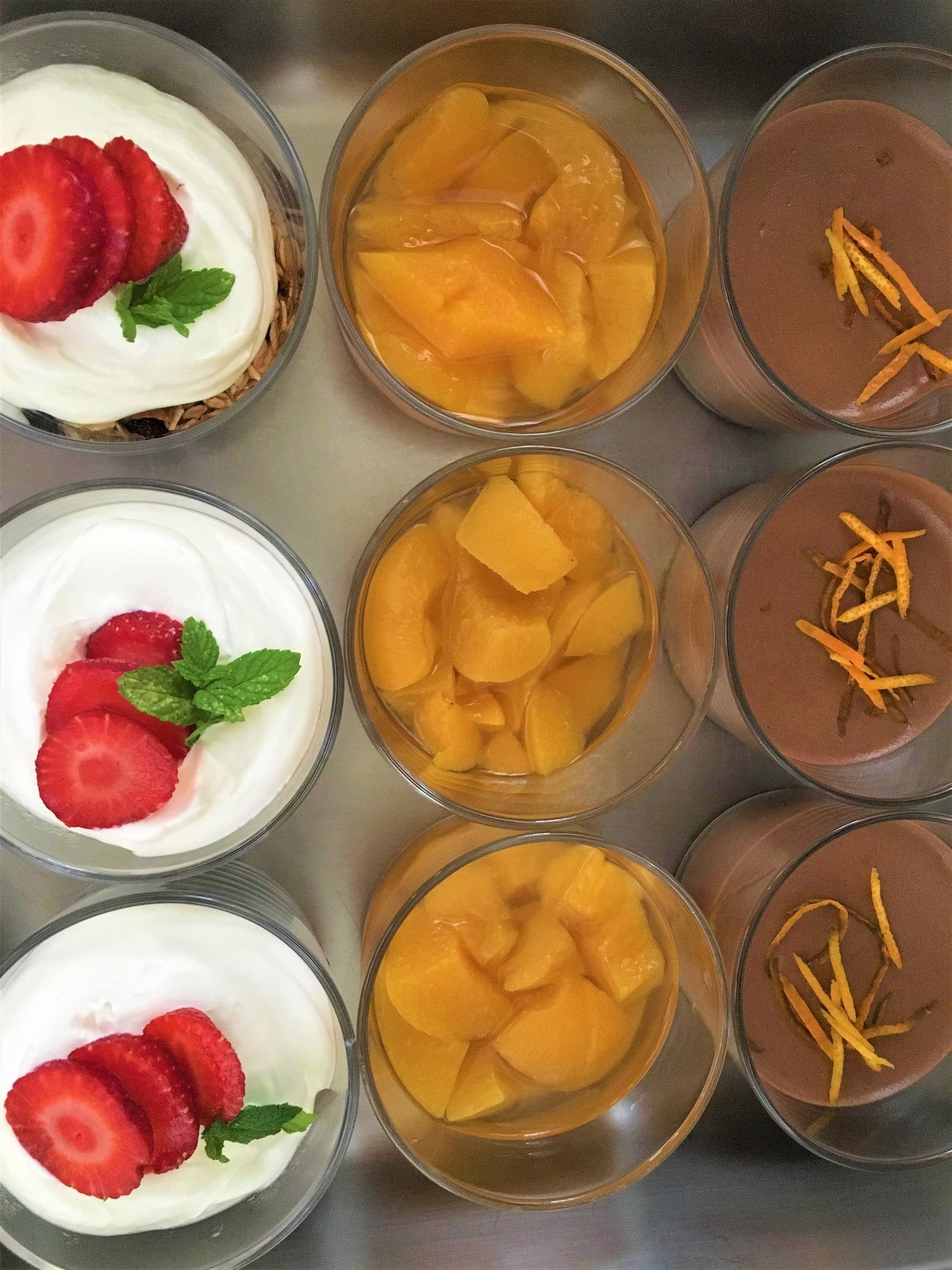A dessert tray with various fruit and cream-based desserts.