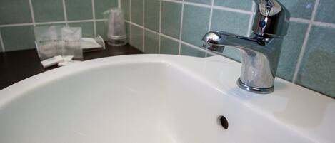 A bathroom sink with a chrome faucet and a small drain hole.