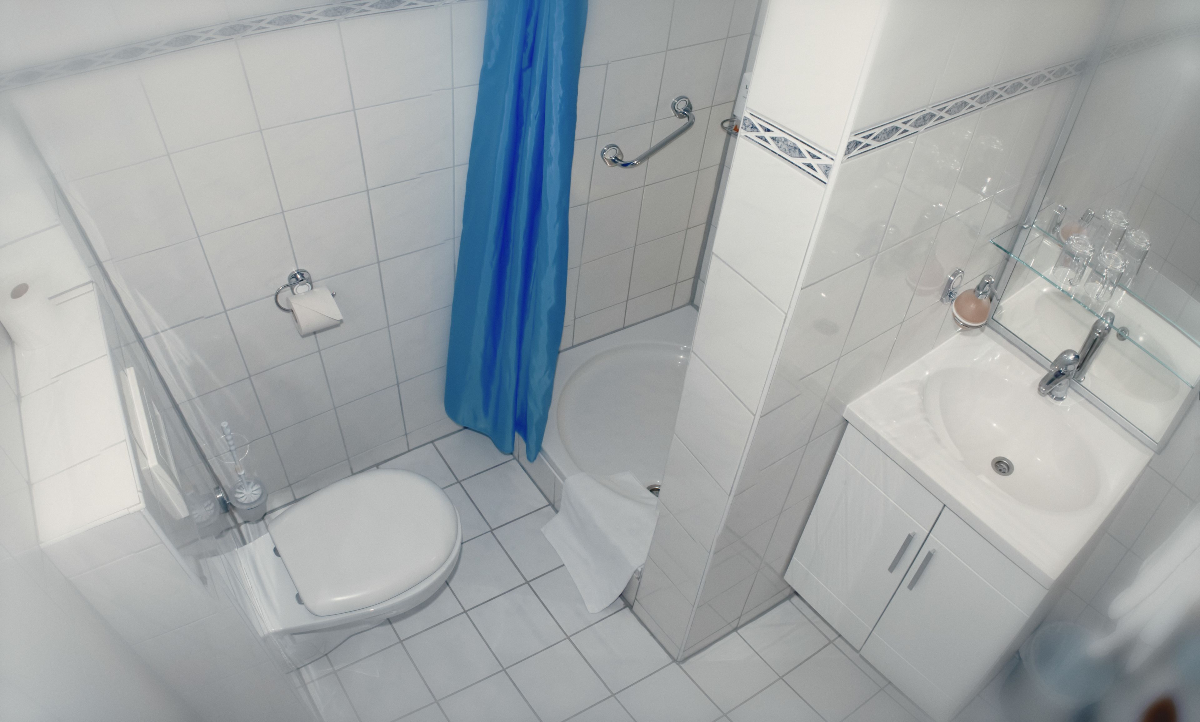 A bathroom with a toilet, a sink, and a shower.