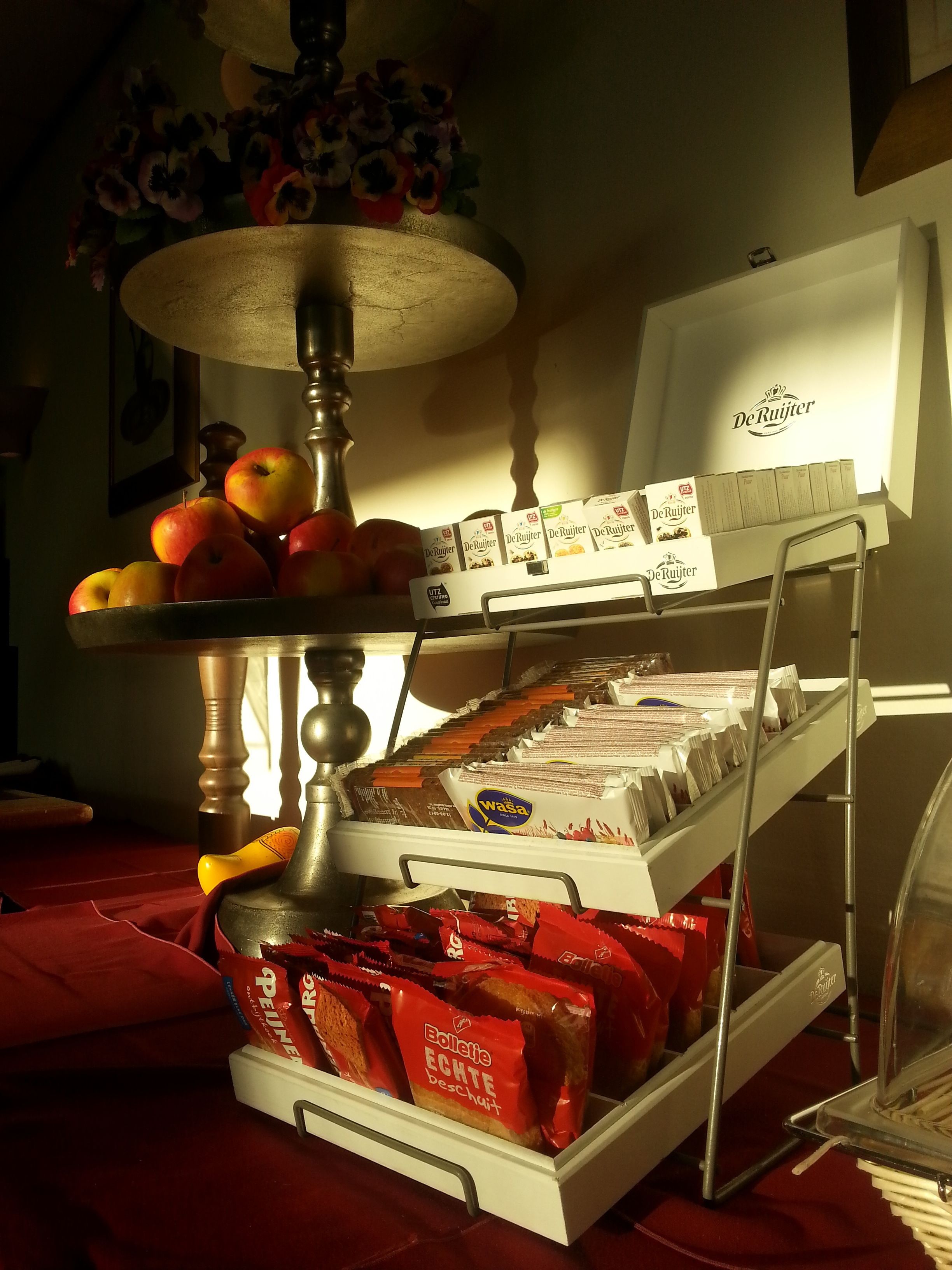 Un buffet proposant une variété d’aliments, notamment des fruits, du pain et des en-cas emballés.