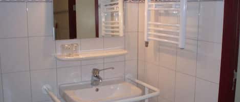 A bathroom with a white sink, mirror, and towel rack.