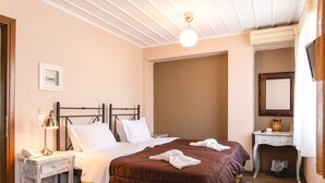 Habitación de hotel con una cama grande, una mesita de noche con lámpara, un escritorio pequeño y un espejo en la pared.