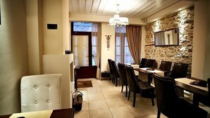 Comedor con pared de piedra, candelabro y vistas al exterior.