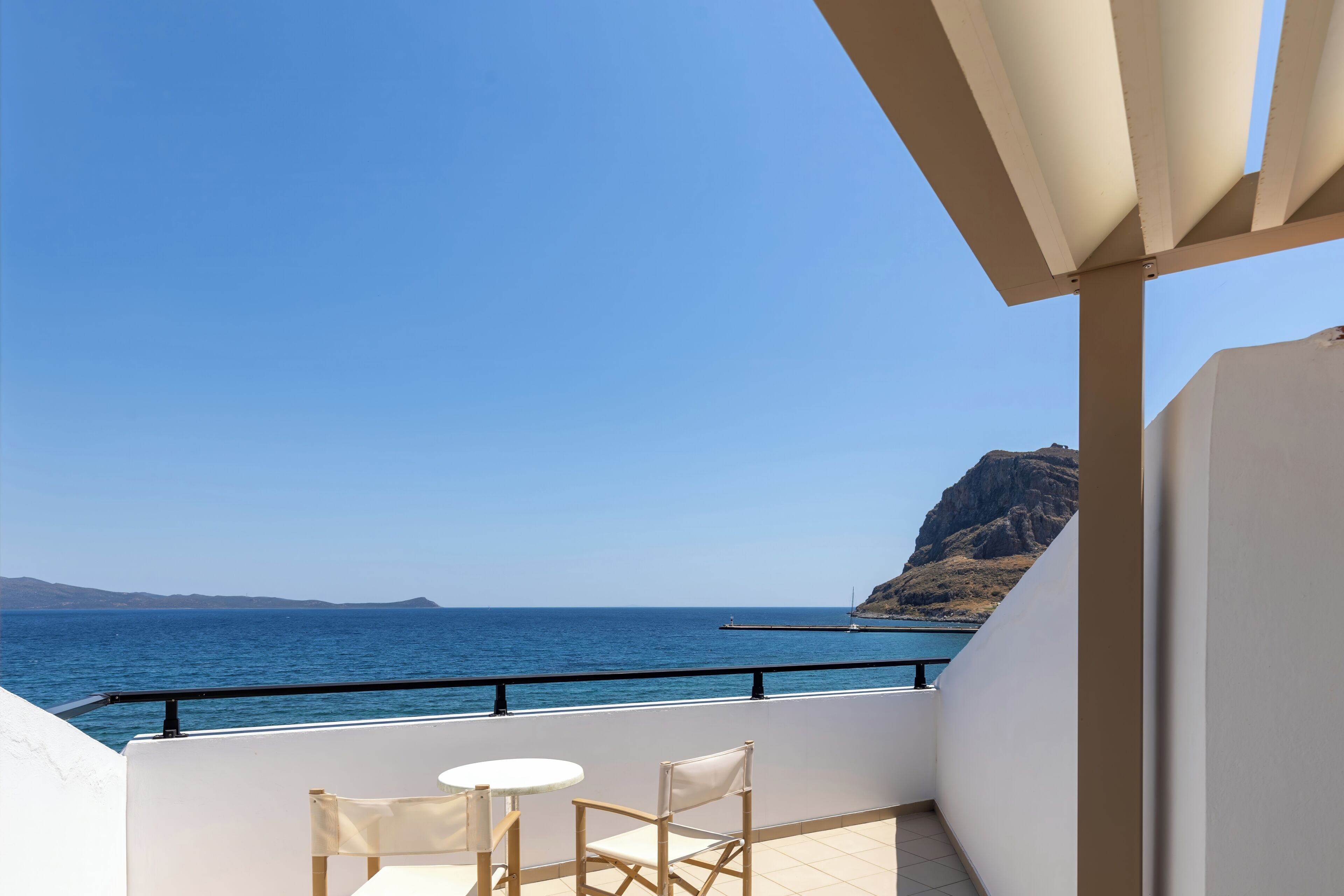 A balcony with a view of the sea and a mountain.