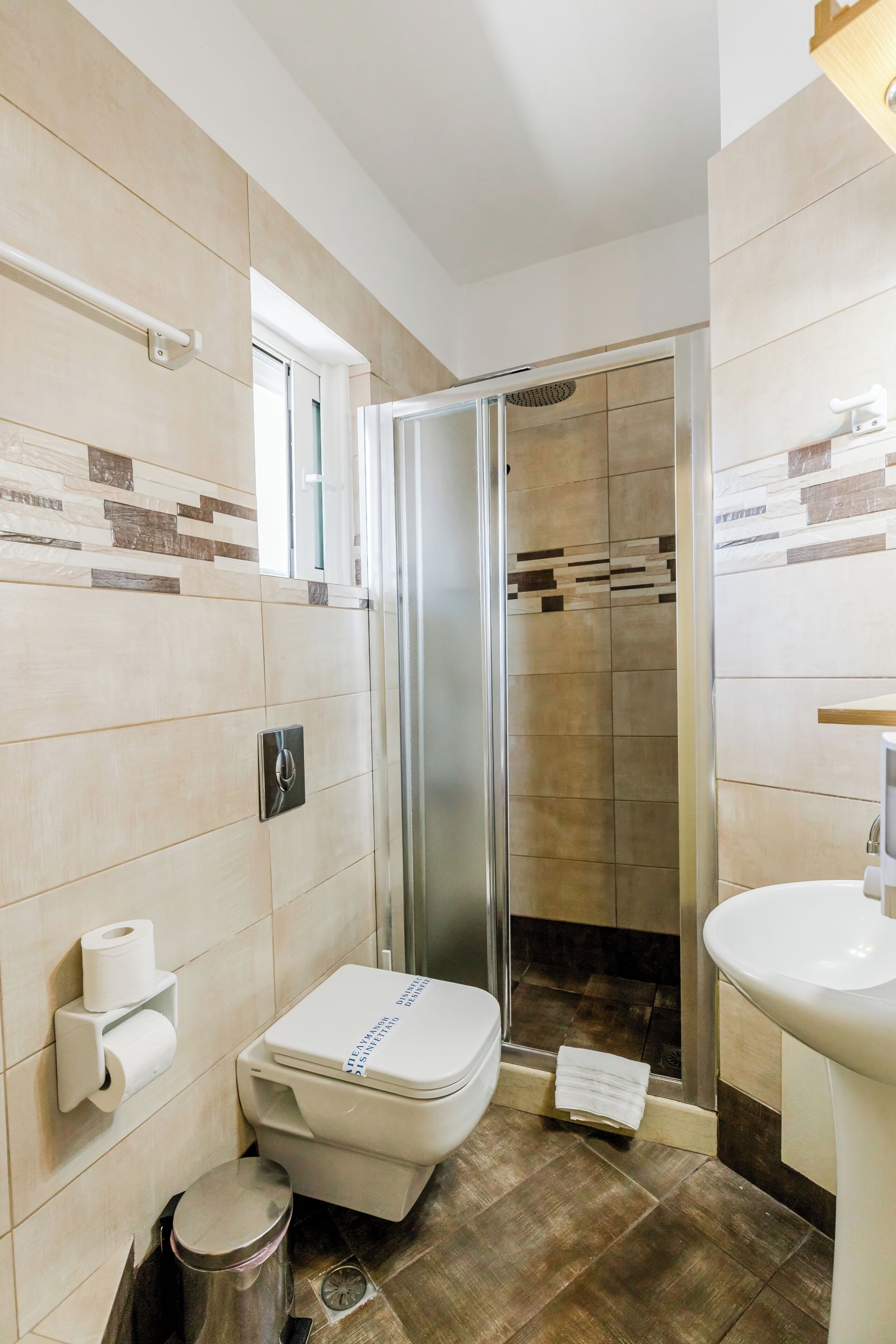 A bathroom with a toilet, sink, and shower area.