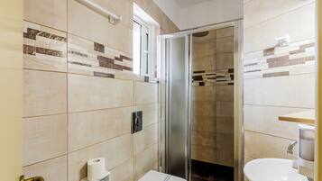 Un baño con ducha, inodoro y lavamanos.
