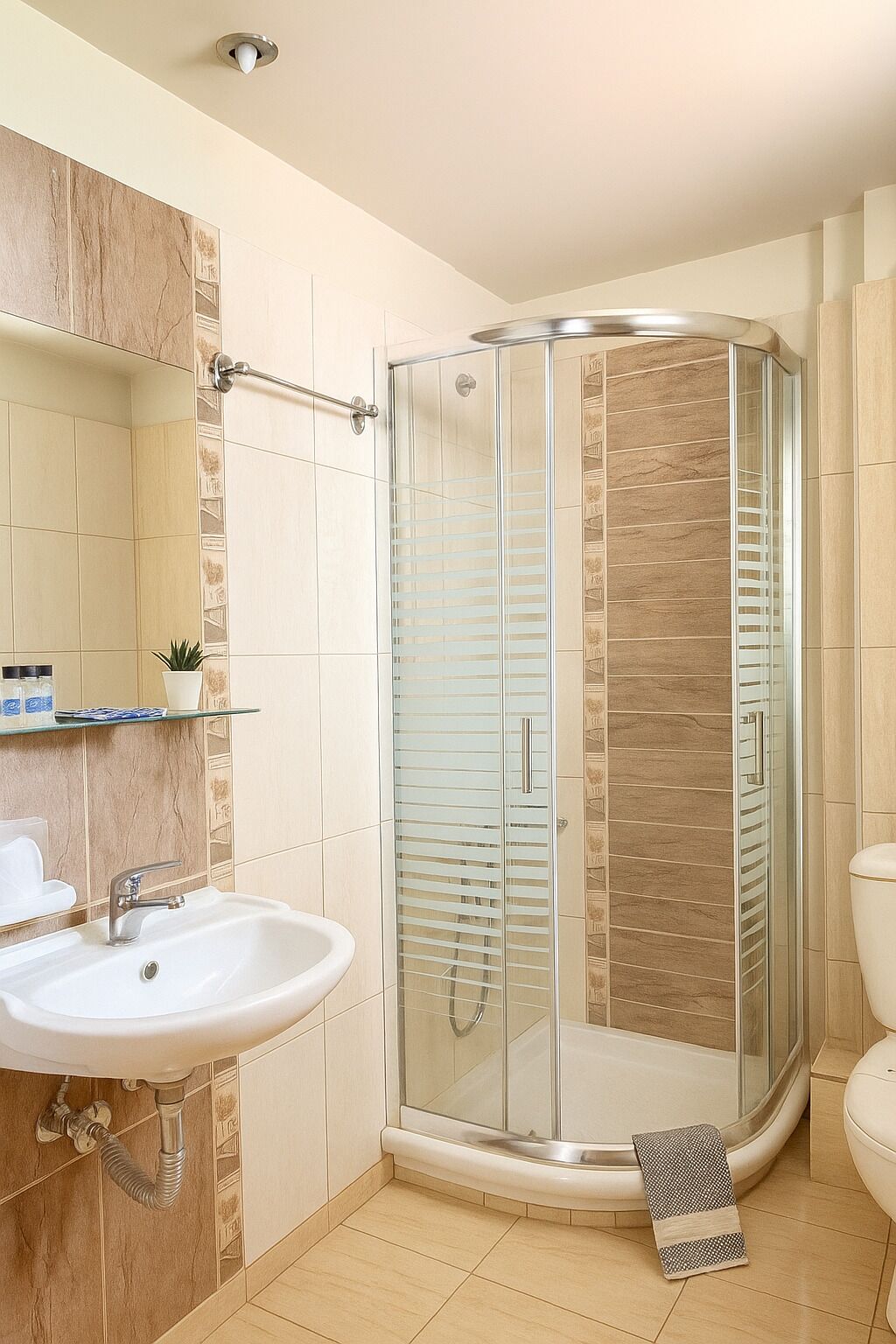 A bathroom with a glass-enclosed shower, a sink, and a toilet.