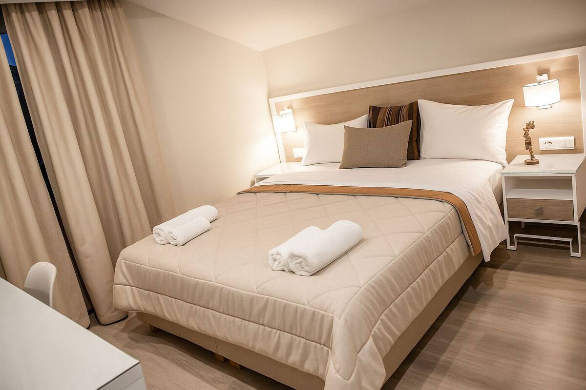Ein Hotelzimmer mit einem Bett, Nachttischen, einem Schreibtisch und einem Sessel.