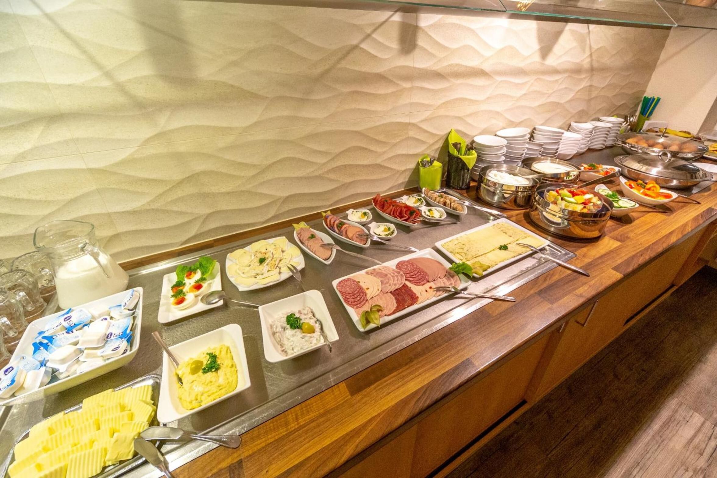 A buffet with various food items and utensils.