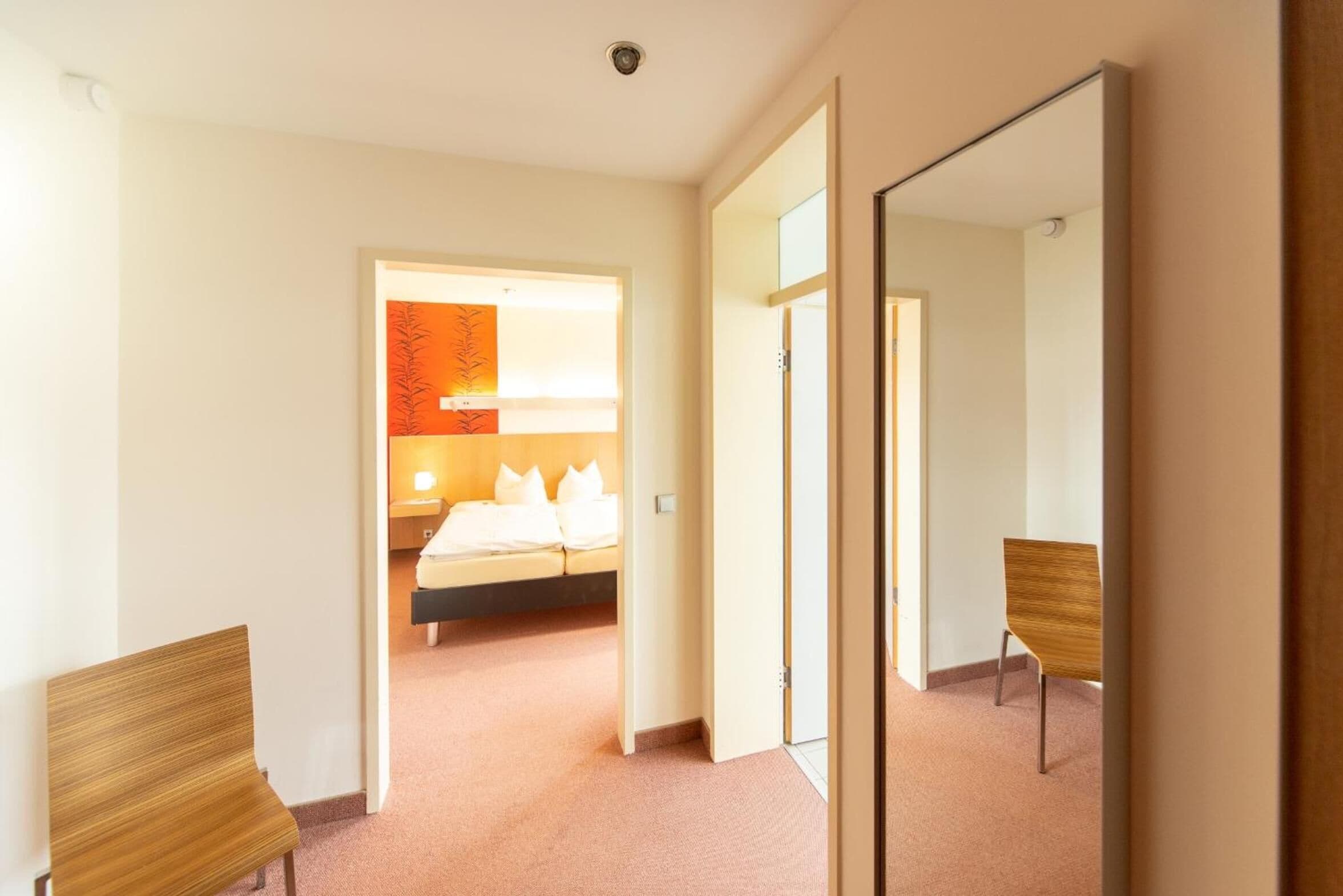 Ein Hotelzimmer mit einem Bett, einem Nachttisch und einem Stuhl.