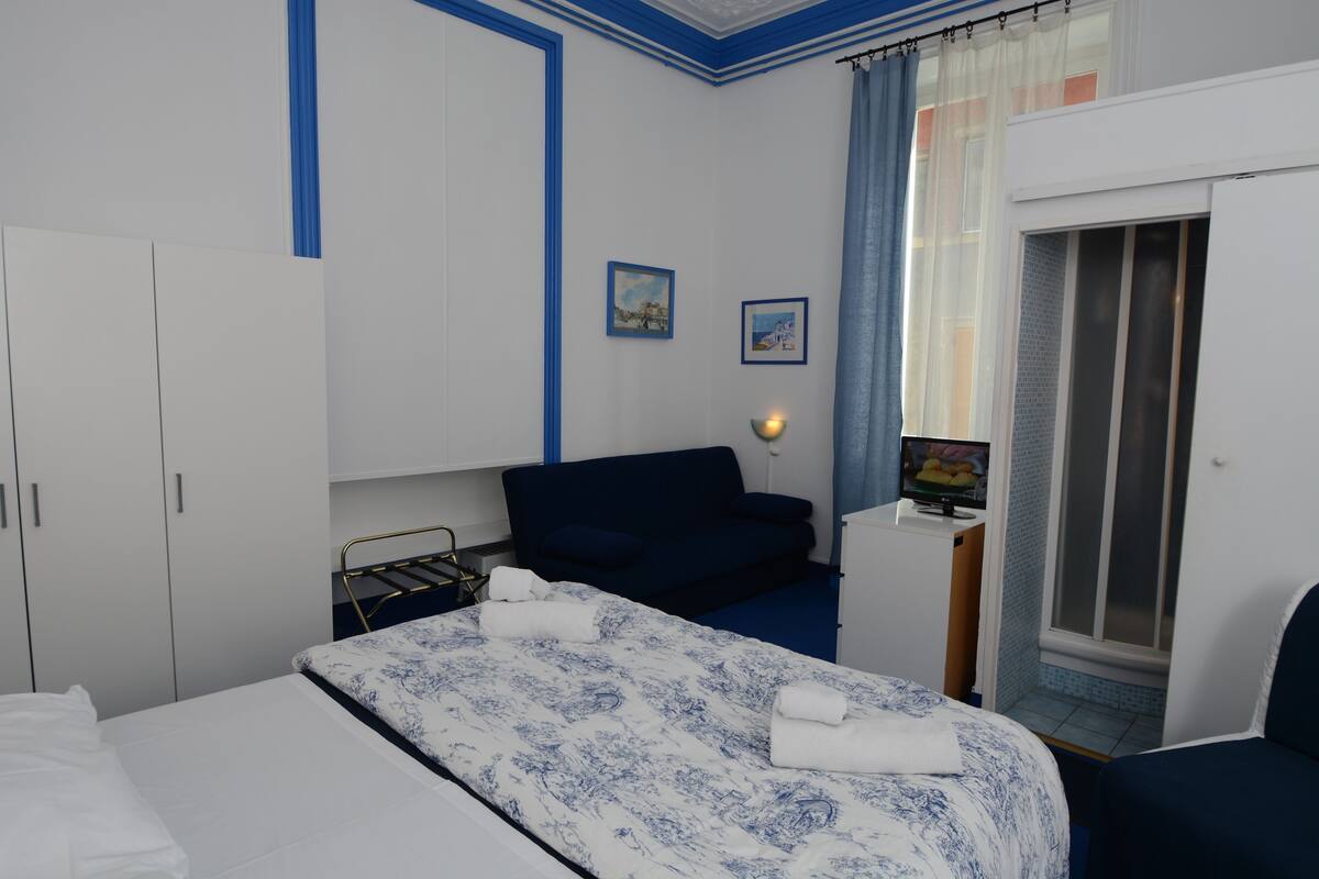A bedroom with a bed, a desk, a chair, and a wardrobe.