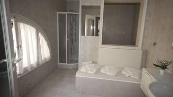 Un baño con ducha, bañera y lavamanos.