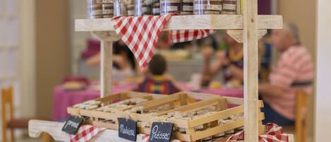 Un carro de madera con varios niveles, con frascos y cestas, probablemente usado para vender productos en un mercado o feria.