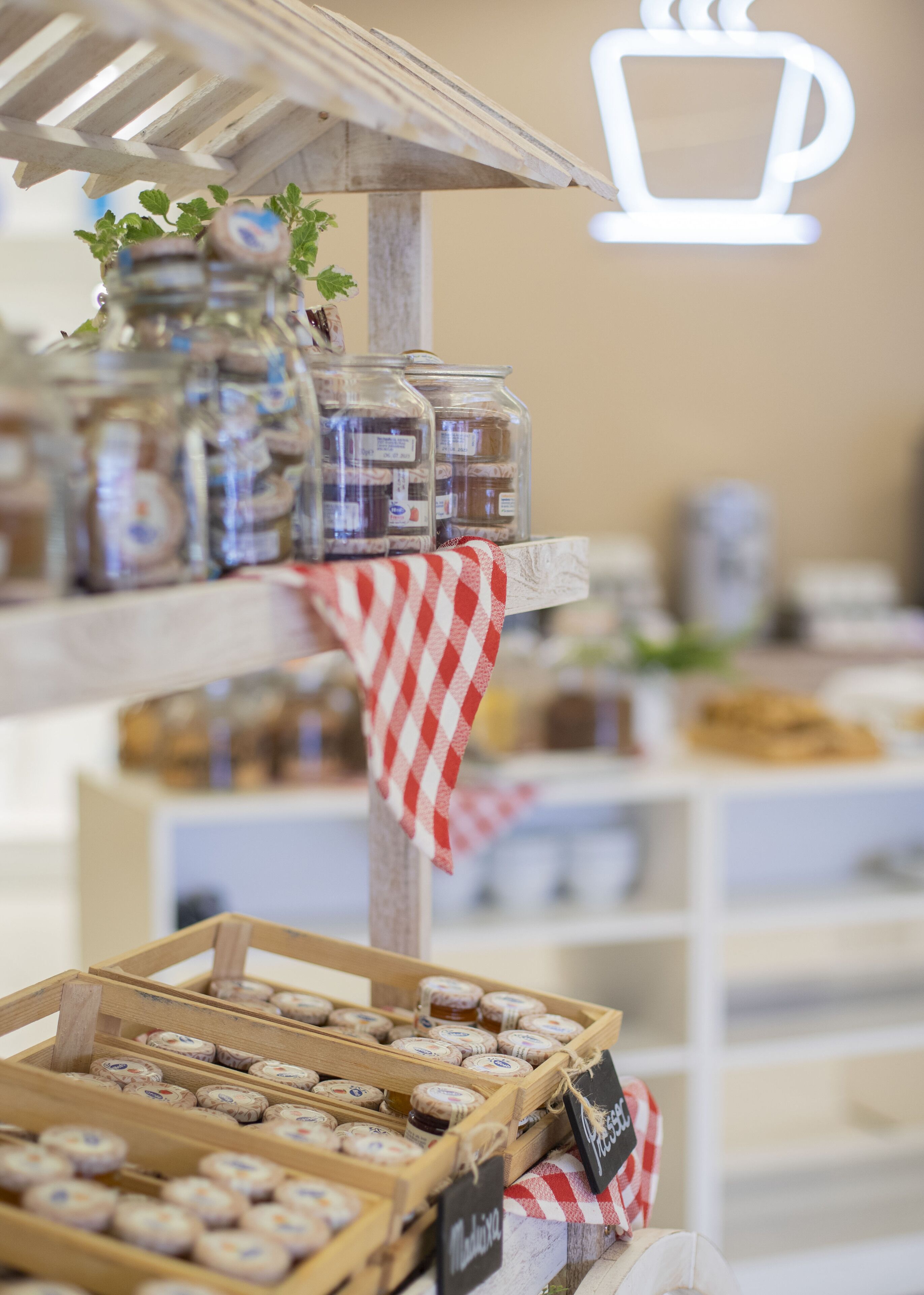 A rustic wooden shelf with jars of preserves and a sign that reads "Preserves."