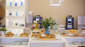Una mesa de buffet con distintos platos y un pastel decorativo.