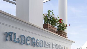 Een gevel met de naam "Albergo La Fontina" in decoratieve letters.