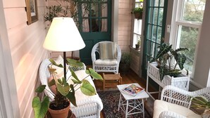 A cozy room with wicker furniture, a potted plant, and a lamp. - Charles Bass House Bed & Breakfast (South Boston)
