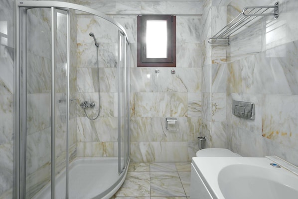 A bathroom with a glass-enclosed shower, a bathtub, and marble flooring. - Mediterranean Village Hotel & Spa (Katerini)