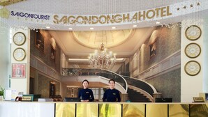 Mostrador de recepción en el Hotel Saigon Tourist, con una gran escalera y candelabros.