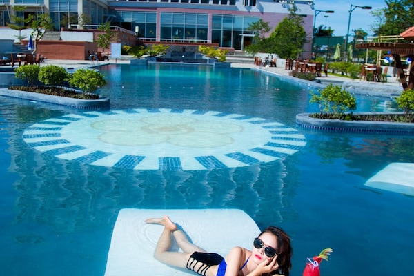 Una piscina al aire libre, sillones reclinables de piscina