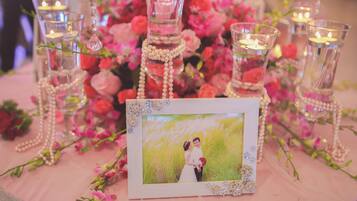 A table with a framed photo, candles, and decorative pearls.