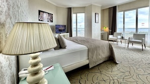 A hotel room with a bed, a TV, a desk, and a view of the city. - Ramada by Wyndham Tekirdag (Tekirdag)