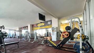 Un gimnasio con diversos equipos de ejercicio, incluyendo máquinas de pesas y pesas libres.